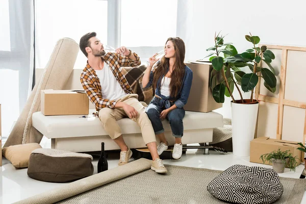 Couple in love drinking champagne at new house with cardboard boxes, moving home concept — Stock Photo