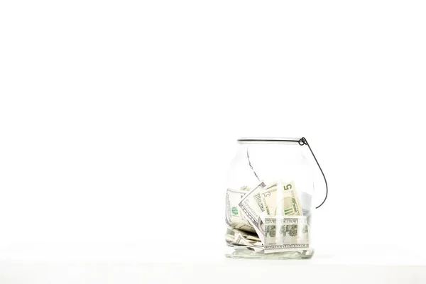 Frasco de vidrio con billetes de dólar aislados sobre fondo blanco - foto de stock