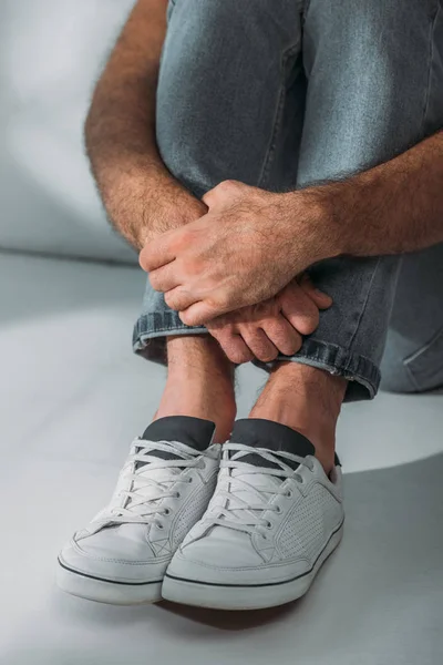 Cropped shot of scared stressed man sitting in floor — Stock Photo