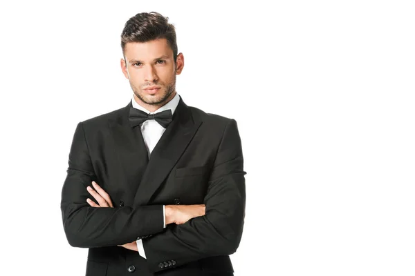 Handsome young man in black suit with bowtie with crossed arms isolated on white — Stock Photo