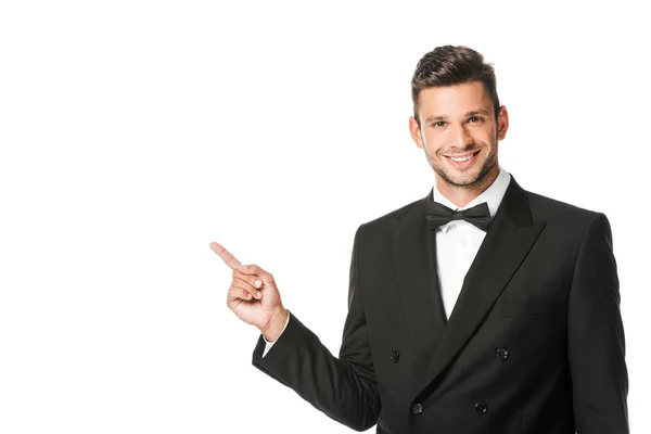 Happy young man in suit pointing at blank space isolated on white — Stock Photo