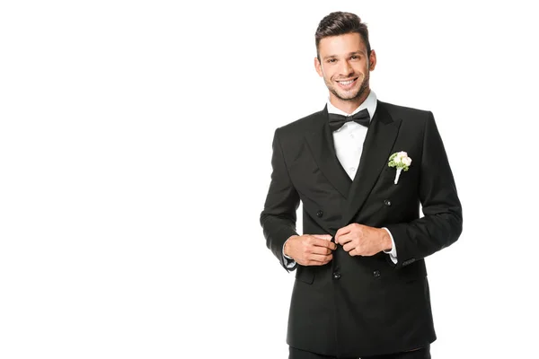 Glücklicher Bräutigam knöpft Anzug und schaut in die Kamera isoliert auf weiß — Stockfoto