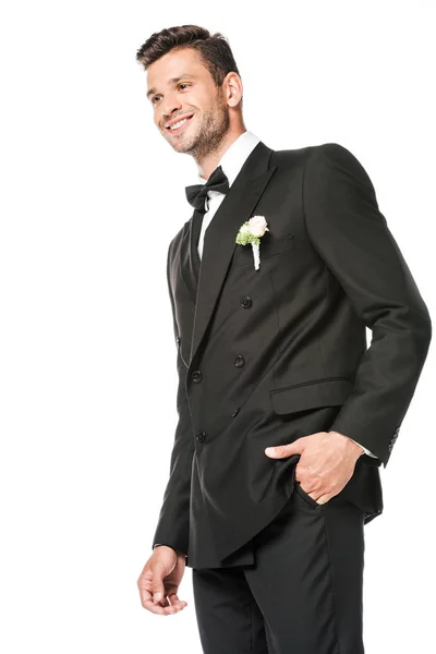 Усміхнений молодий наречений у стильному костюмі з бутоньєрою ізольований на білому — стокове фото
