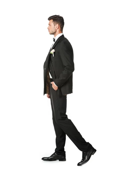 Vista lateral do belo noivo jovem em terno elegante isolado no branco — Fotografia de Stock