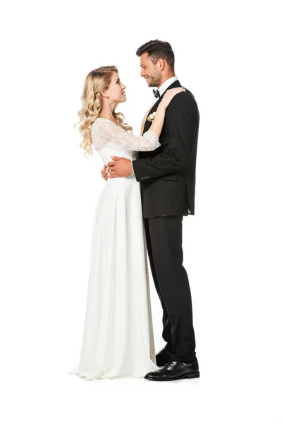 Side view of young bride and groom embracing isolated on white — Stock Photo