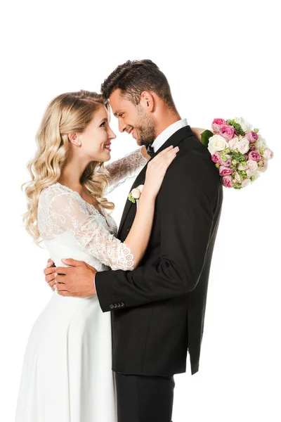 Happy newlyweds embracing and looking at each other isolated on white — Stock Photo