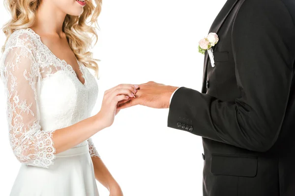 Abgeschnittene Aufnahme einer jungen Braut, die einen Ehering am Finger des Bräutigams anlegt, isoliert auf Weiß — Stockfoto