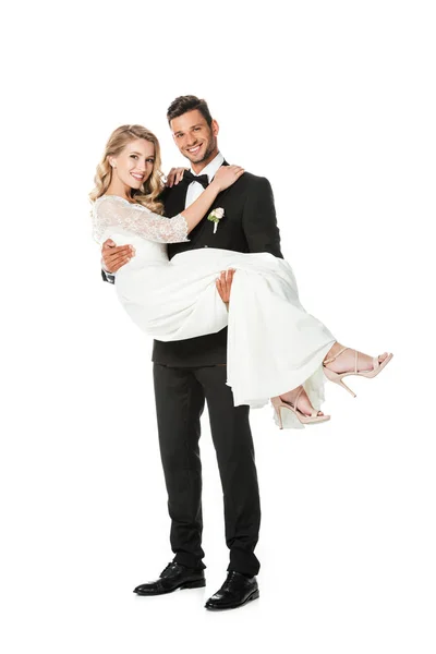 Handsome young groom carrying his bride isolated on white — Stock Photo