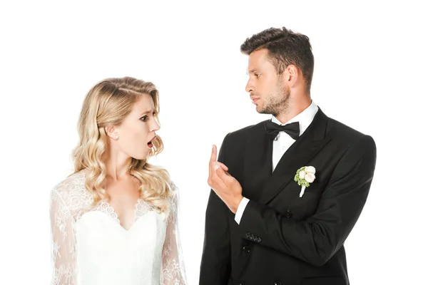 Novio mostrando el dedo medio a la novia conmocionada aislado en blanco - foto de stock