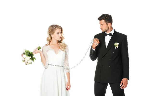 Young groom with chain and leashed bride looking at each other isolated on white — Stock Photo