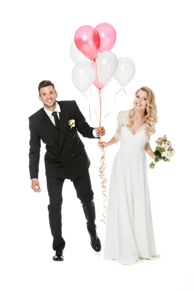 Happy young bride and groom with air balloons isolated on white — Stock Photo