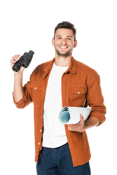 Happy young man with binoculars and rolled map looking at camera isolated on white — Stock Photo