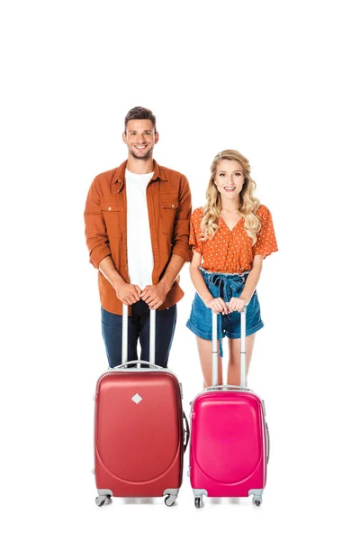 Glückliches junges Paar mit Koffern blickt isoliert auf weiße Kamera — Stockfoto
