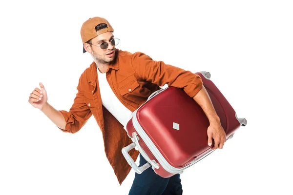 Vista lateral del guapo turista corriendo con bolsa de viaje aislada en blanco - foto de stock