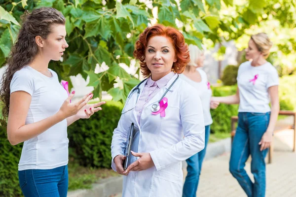 Femme parlant avec un médecin à l'extérieur, concept de sensibilisation au cancer du sein — Photo de stock