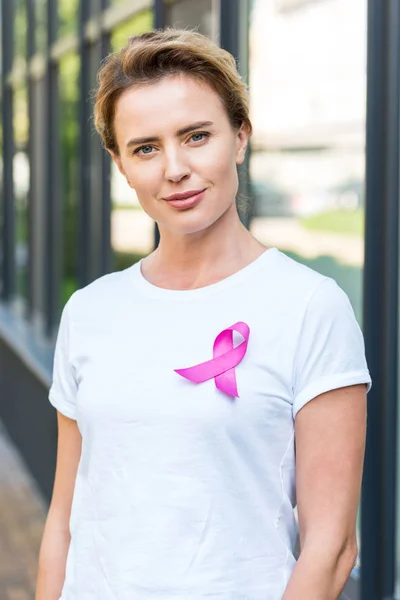 Donna con nastro rosa guardando la fotocamera, concetto di consapevolezza del cancro al seno — Foto stock