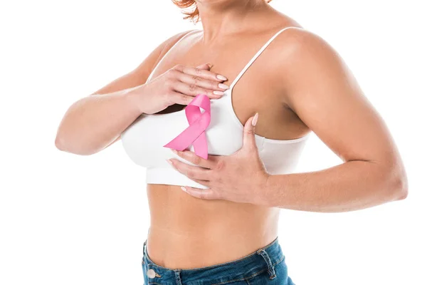 Обрезанный снимок женщины в белых трусах с розовой лентой, касающейся груди, изолированной на белом, концепция информированности о раке — стоковое фото
