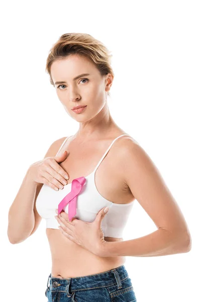 Mulher em sutiã com fita rosa verificando mama e olhando para câmera isolada em branco, conceito de consciência do câncer — Fotografia de Stock