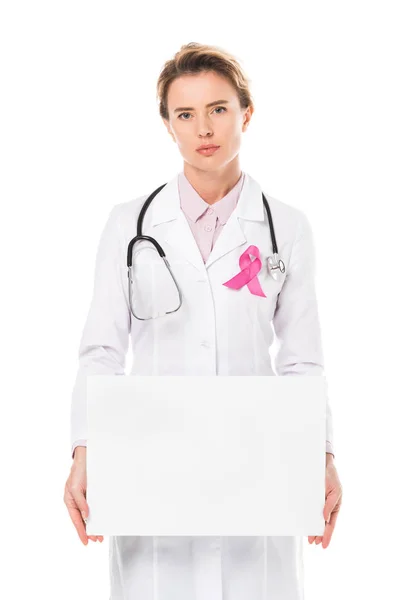 Doctor with pink ribbon holding blank banner and looking at camera isolated on white, breast cancer awareness concept — Stock Photo