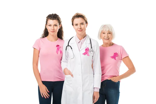 Médico y mujeres con cintas de conciencia de cáncer de mama mirando a la cámara aislada en blanco - foto de stock