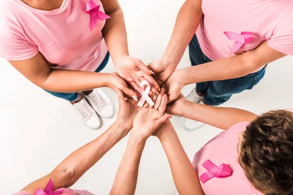 Обрізаний знімок жінок у рожевих футболках, що тримають стрічку обізнаності про рак молочної залози ізольовано на білому — стокове фото