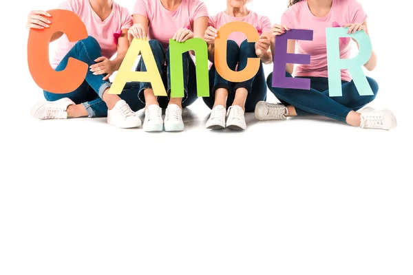 Foto recortada de las mujeres en camisetas de color rosa con letras de colores con la palabra cáncer aislado en blanco - foto de stock