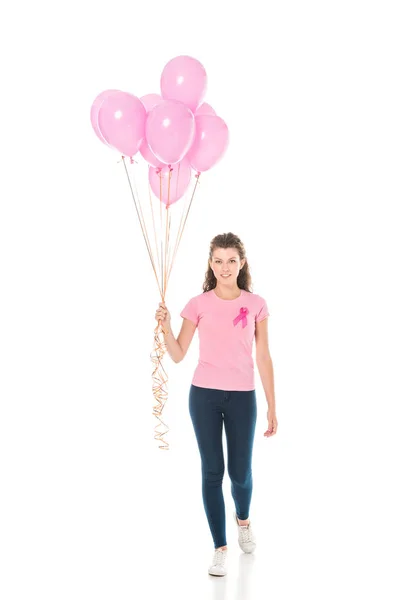 Молода жінка тримає купу рожевих кульок і посміхається на камеру ізольовано на білому, концепція раку молочної залози — стокове фото