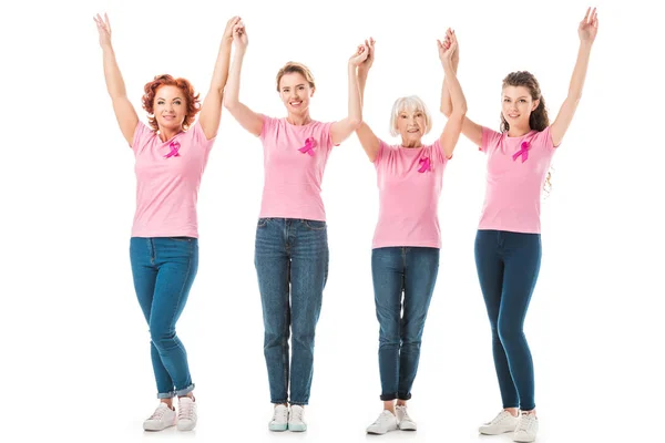 Femmes avec des rubans de sensibilisation au cancer du sein tenant la main et souriant à la caméra isolé sur blanc — Photo de stock