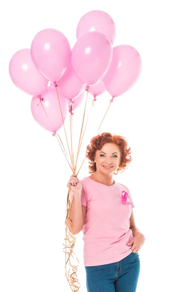 Happy mature woman holding bunch of pink balloons and smiling at camera isolated on white, breast cancer concept — Stock Photo