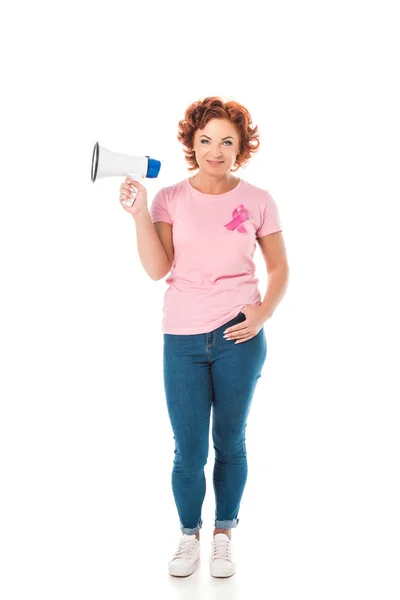 Mujer en camiseta rosa con cinta de conciencia de cáncer de mama sosteniendo megáfono y sonriendo a la cámara aislada en blanco - foto de stock