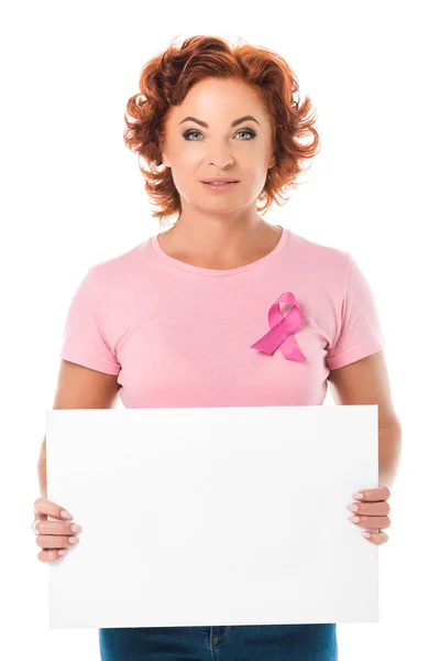 Mujer madura en camiseta rosa con cinta de conciencia de cáncer de mama sosteniendo pancarta en blanco y mirando a la cámara aislada en blanco - foto de stock