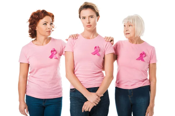 Women in pink t-shirts with breast cancer awareness ribbons standing together isolated on white — Stock Photo
