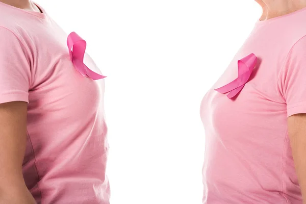 Vista lateral parcial de las mujeres con cintas de color rosa aisladas en blanco, concepto de conciencia del cáncer de mama - foto de stock
