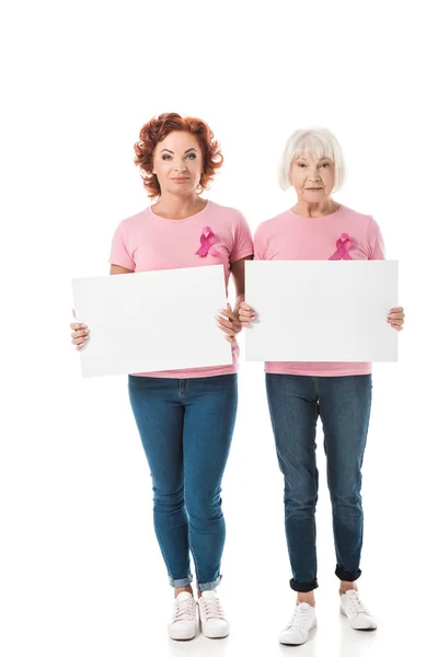 Femmes avec des rubans roses tenant des bannières vierges et regardant la caméra isolée sur blanc, concept de sensibilisation au cancer du sein — Photo de stock