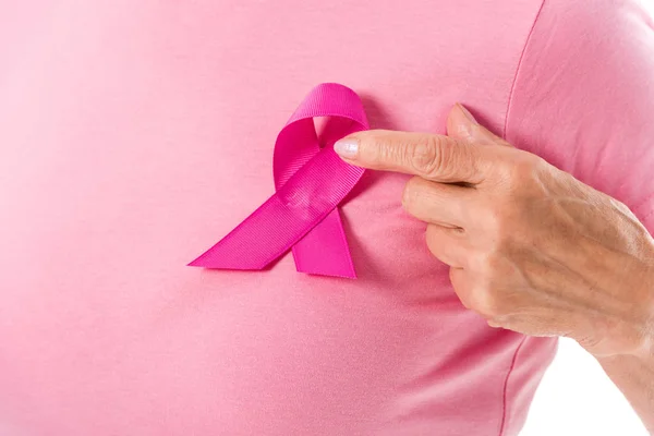 Cropped shot of woman in pink t-shirt pointing with finger at breast cancer ribbon — Stock Photo