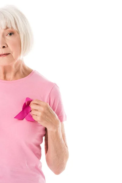 Foto ritagliata di donna anziana in t-shirt rosa con nastro di consapevolezza del cancro al seno guardando la fotocamera isolata su bianco — Foto stock