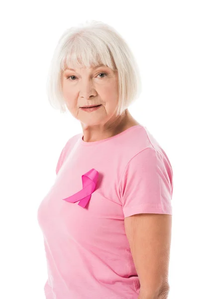 Senior woman in pink t-shirt with breast cancer awareness ribbon looking at camera isolated on white — Stock Photo