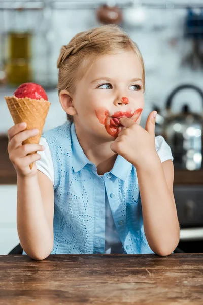 Прелестный маленький ребенок ест сладкое мороженое и облизывает палец — Stock Photo