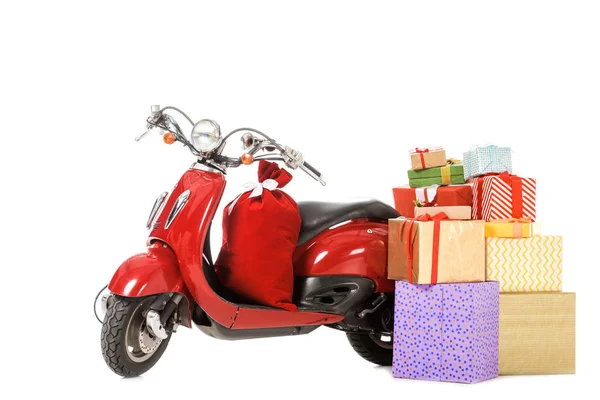 Scooter vintage rojo con pila de regalos de Navidad aislados en blanco - foto de stock