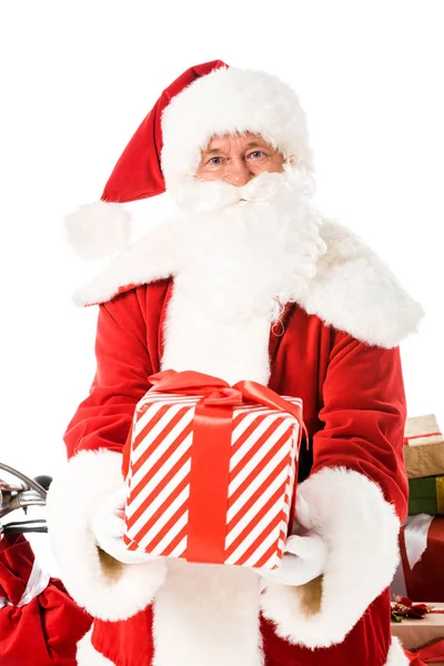 Weihnachtsmann hält gestreifte Geschenkschachtel in der Hand und blickt isoliert auf weiße Kamera — Stockfoto