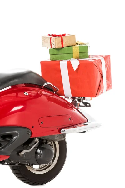 Partial view of red scooter with stack of christmas gifts isolated on white — Stock Photo