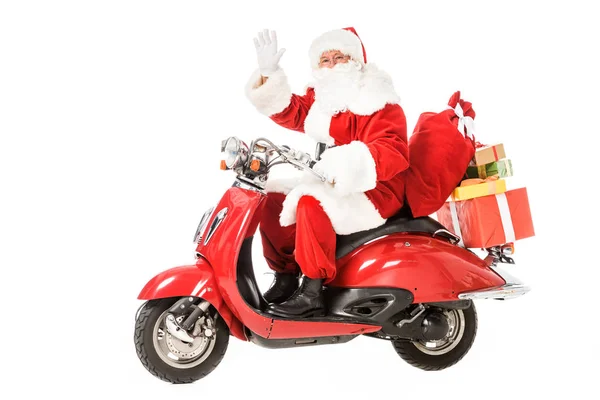 Санта Клаус ездит на винтажном красном скутере и машет на камеру изолированы на белом — стоковое фото