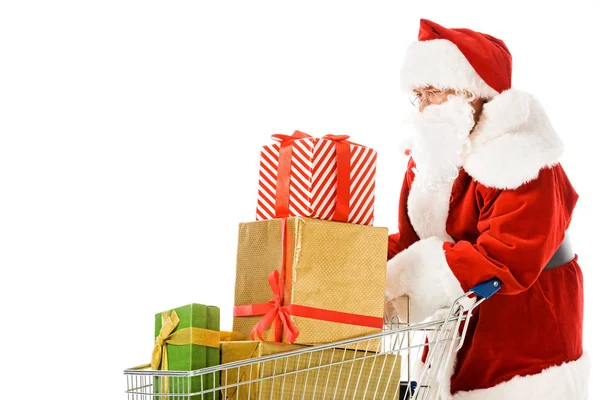 Santa claus with shopping cart full of gift boxes isolated on white — Stock Photo