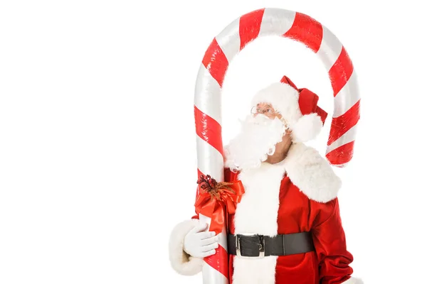 Santa claus with giant candy cane looking up isolated on white — Stock Photo