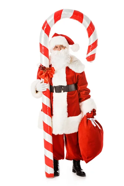 Weihnachtsmann mit riesigem Zuckerrohr und Sack blickt isoliert auf weiße Kamera — Stockfoto
