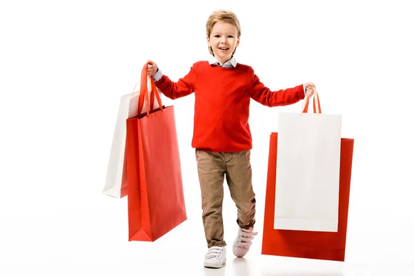 Happy little kid holding big shopping bags isolated on white — Stock Photo