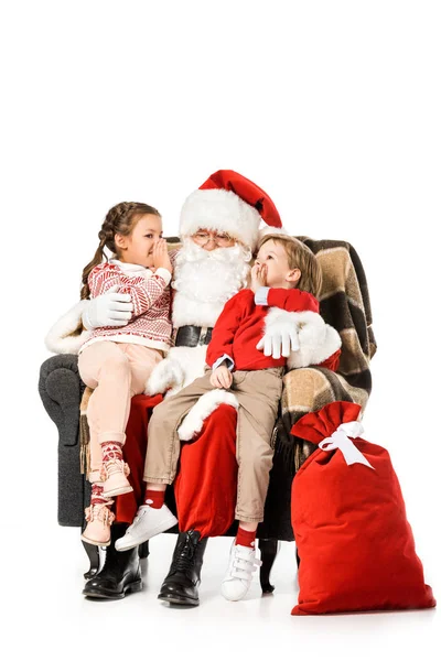 Kinder flüstern dem Weihnachtsmann zu, während thay im Sessel zusammen isoliert auf weiß sitzt — Stockfoto