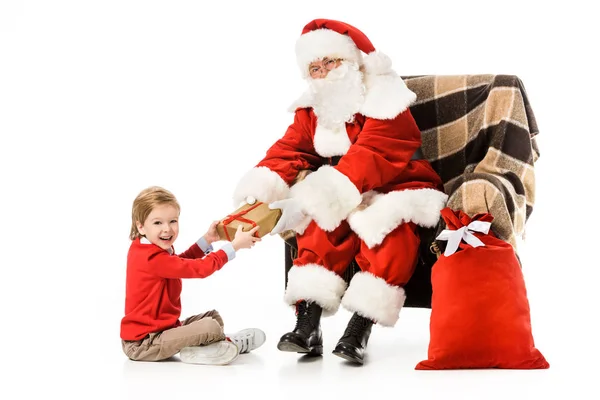 Santa presenta regalo de Navidad a niño emocionado aislado en blanco - foto de stock