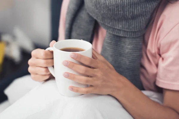 Schnittwunden an kranker Frau im Bett mit heißem Tee — Stockfoto