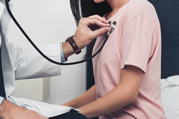 Cropped shot of doctor listening breath of female patient — Stock Photo